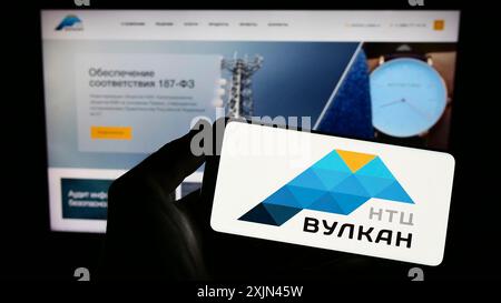 Stoccarda, Germania, 03-31-2023: Persona con smartphone e logo della società russa di tecnologie dell'informazione NTC Vulkan sullo schermo di fronte Foto Stock