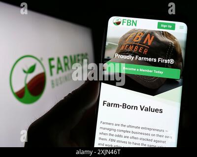 Stoccarda, Germania, 03-31-2023: Persona che possiede uno smartphone con pagina web della piattaforma Farmers Business Network (FBN) sullo schermo con logo. Concentrati su Foto Stock