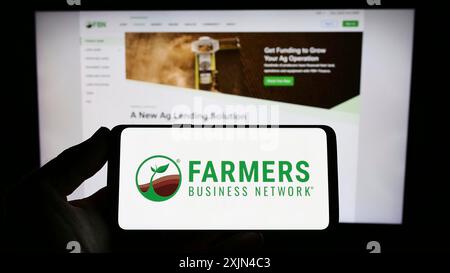 Stoccarda, Germania, 03-31-2023: Persona con smartphone con logo della piattaforma agricola Farmers Business Network (FBN) sullo schermo di fronte Foto Stock