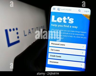 Stoccarda, Germania, 04-23-2023: Persona che detiene il cellulare con il sito web della società finanziaria australiana Latitude Group sullo schermo davanti al logo. Foto Stock