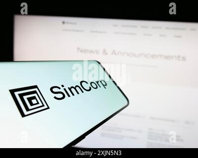 Stoccarda, Germania, 04-28-2023: Telefono cellulare con logo della società danese di software finanziari SimCorp sullo schermo di fronte al sito web aziendale. Concentrati Foto Stock