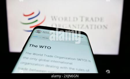 Stoccarda, Germania, 03-25-2023: Smartphone con sito web dell'Organizzazione mondiale del commercio (OMC) sullo schermo davanti al logo. Concentrati sulla parte superiore sinistra del telefono Foto Stock