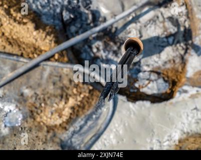 Tubi di rivestimento con anello di messa a terra in polietilene in fase di installazione in un nuovo campo di pozzi geotermici. Foto Stock