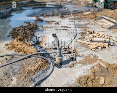 Tubi di rivestimento con anello di messa a terra in polietilene in fase di installazione in un nuovo campo di pozzi geotermici. Foto Stock