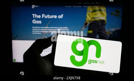 Stoccarda, Germania, 06-18-2023: Persona che detiene il cellulare con il logo della società ceca di distribuzione del gas GasNet sro sullo schermo davanti all'azienda Foto Stock