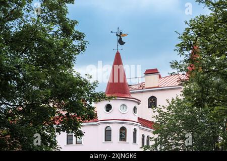 Vyborg, Russia - 10 giugno 2024: Edificio d'epoca con una bella pala meteorologica a forma di angelo tromba Foto Stock