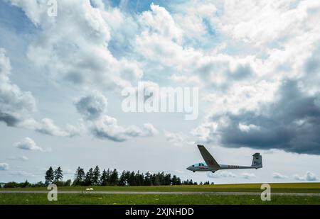 PRODUZIONE - 18 luglio 2024, Assia, Gersfeld (Röhn): Un aliante decolla dal campo d'aviazione più alto della Germania (circa 920 metri) sul Wasserkuppe con l'aiuto di un verricello. Foto: Andreas Arnold/dpa Foto Stock