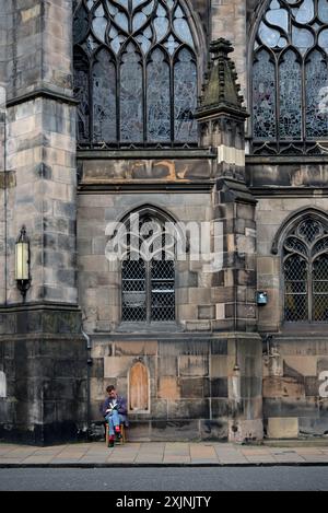 Giovane seduto a leggere in Parliament Square nella città vecchia di Edimburgo. Foto Stock