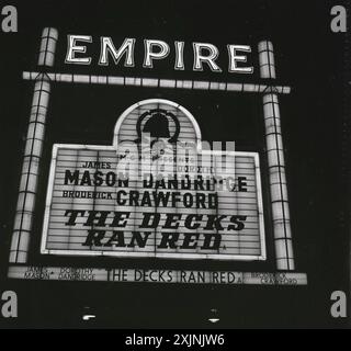 1958, Historical, The Empire Cinema in Leicester Square, Londra, Inghilterra, Regno Unito che mostra il film della MGM The Decks Ran Red, con James Mason, Dorothy Dandridge e Broderick Crawford. Originariamente costruito nel 1884 come teatro di varietà, l'Empire fu acquisito nel 1925 dalla Metro-Goldwyn-Mayer e ricostruito come un cinema per mostrare film. Foto Stock