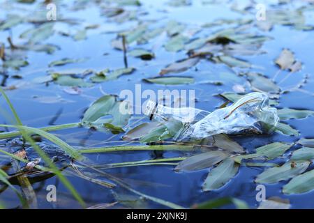 Bottiglia di plastica in acqua, lago o fiume. Inquinamento da plastica. Inquinamento dei bacini e dei fiumi. Spazzatura nel fiume da vicino. Un floa di bottiglie abbandonato Foto Stock