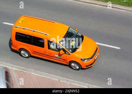 OSTRAVA, REPUBBLICA CECA - 11 MAGGIO 2024: Taxi arancione Volkswagen Caddy III auto della società VaseTaxi, effetto motion blur Foto Stock