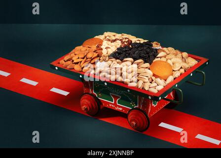 Carrello decorativo riempito con un assortimento di frutta secca e frutta secca su una strada rossa. Foto Stock
