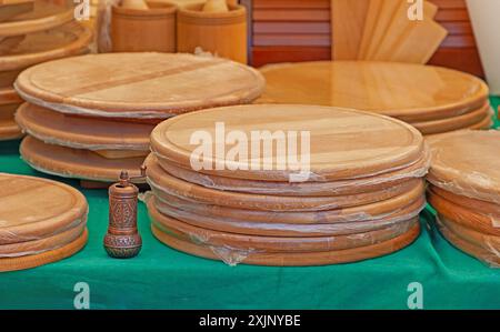 Una pila di taglieri di legno fatti in casa all'esterno su un mercato Foto Stock