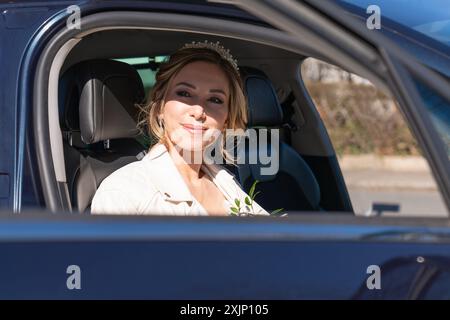 ritratto ravvicinato di una sposa nel finestrino di un'auto che guarda fuori dal finestrino Foto Stock