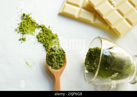 Polvere di matcha organica in cucchiaio di legno con sfondo bianco Foto Stock
