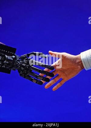 Una mano robotica si estende verso una mano umana, entrambe raggiungendo con un gesto di connessione e interazione. La mano robotica è realizzata in metallo nero e. Foto Stock