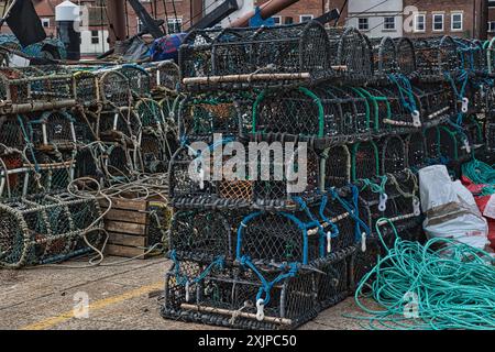 Una pila di tagliole di aragosta con corde e boe su un molo, pronte per l'uso nella pesca. Foto Stock