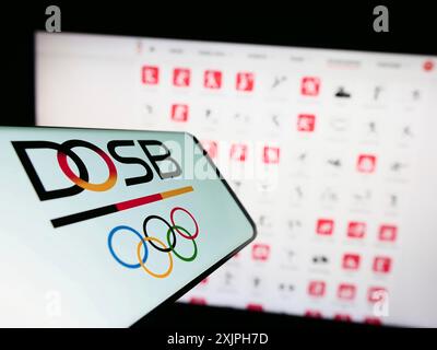 Stoccarda, Germania, 06-17-2023: Smartphone con logo organizatin Deutscher Olympischer Sportbund (DOSB) sullo schermo davanti al sito web. Concentrati su Foto Stock