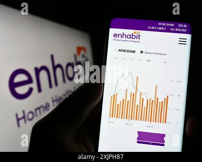 Stoccarda, Germania, 06-17-2023: Persona che tiene il cellulare con la pagina web di Enhabit Home Health e Hospice Corporation sullo schermo davanti al logo. Foto Stock