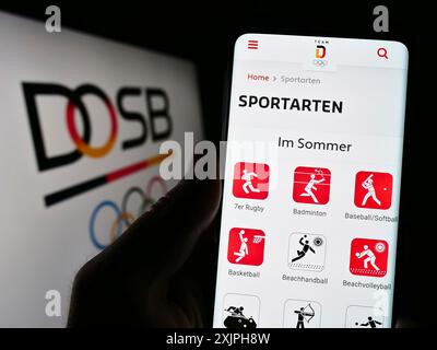 Stoccarda, Germania, 06-17-2023: Persona che tiene il cellulare con pagina web dell'organizatin Deutscher Olympischer Sportbund (DOSB) sullo schermo con logo. Foto Stock