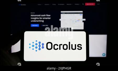 Stoccarda, Germania, 06-18-2023: Persona che possiede uno smartphone con il logo della società statunitense di automazione dei documenti Ocrolus Inc. Sullo schermo davanti al sito web. Foto Stock
