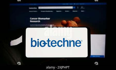 Stoccarda, Germania, 06-24-2023: Persona che tiene un cellulare con il logo della società statunitense di scienze della vita Bio-Techne Corporation sullo schermo davanti alla pagina web. Foto Stock