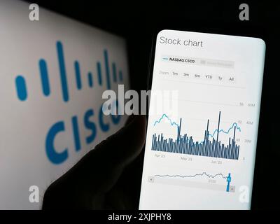 Stoccarda, Germania : 06-25-2023: Persona che detiene il cellulare con pagina web della società di comunicazioni statunitense Cisco Systems Inc. Su schermo con logo. Concentrati su Foto Stock