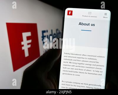 Stoccarda, Germania, 07-04-2023: Persona che detiene il cellulare con pagina web della società finanziaria Fidelity International Ltd. Su schermo con logo. Concentrati su Foto Stock