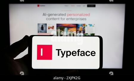 Stoccarda, Germania, 07-08-2023: Persona con smartphone con logo della società statunitense di intelligenza artificiale Typeface Inc. Sullo schermo di fronte Foto Stock