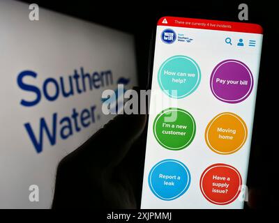 Stoccarda, Germania, 07-28-2023: Persona che possiede uno smartphone con sito web della società britannica Southern Water Services Limited sullo schermo con logo. Concentrati Foto Stock