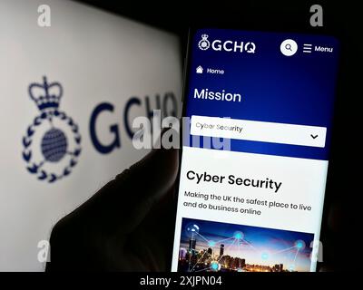 Stoccarda, Germania, 07-30-2023: Persona che detiene un cellulare con sito web della sede centrale delle comunicazioni governative (GCHQ) sullo schermo con logo. Concentrati su Foto Stock