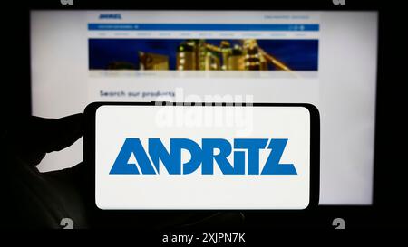 Stoccarda, Germania, 08-02-2023: Persona che detiene il cellulare con il logo della società industriale austriaca Andritz AG sullo schermo davanti alla pagina web aziendale. Foto Stock