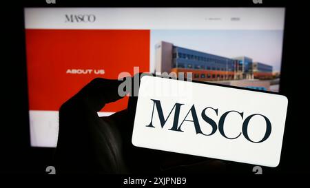 Stoccarda, Germania, 08-04-2023: Persona che tiene il cellulare con il logo della società americana di miglioramento della casa Masco Corporation sullo schermo di fronte Foto Stock