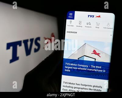 Stoccarda, Germania, 08-05-2023: Persona che detiene il cellulare con il sito web della società motociclistica TVS Motor Company Limited sullo schermo con il logo. Concentrati su Foto Stock