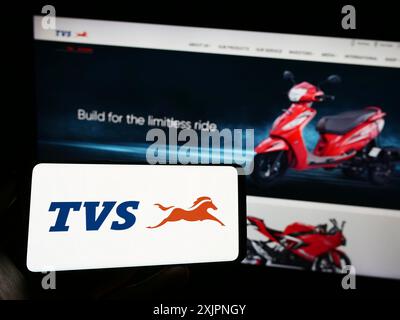 Stoccarda, Germania, 08-05-2023: Persona che detiene un cellulare con il logo della società motociclistica TVS Motor Company Limited sullo schermo davanti alla pagina web. Foto Stock