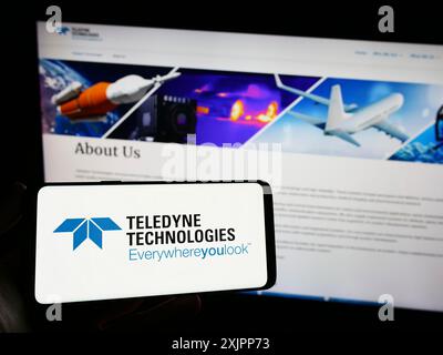 Stoccarda, Germania, 08-09-2023: Persona che possiede uno smartphone con logo della società statunitense Teledyne Technologies incorporato sullo schermo davanti al sito web. Foto Stock