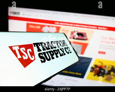 Stoccarda, Germania, 08-11-2023: Telefono cellulare con logo American retail business Tractor Supply Company sullo schermo davanti al sito Web. Concentrati su Foto Stock