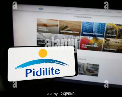 Stoccarda, Germania, 08-28-2023: Persona che detiene il cellulare con il logo della società indiana Pidilite Industries Limited sullo schermo davanti all'azienda Foto Stock