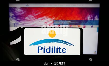 Stoccarda, Germania, 08-28-2023: Persona che detiene uno smartphone con il logo della società indiana Pidilite Industries Limited sullo schermo davanti al sito web. Foto Stock