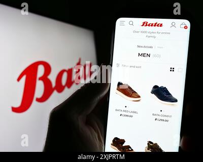 Stoccarda, Germania, 08-29-2023: Persona che detiene il cellulare con pagina web della società di calzature Bata Corporation sullo schermo davanti al logo. Concentrati su Foto Stock