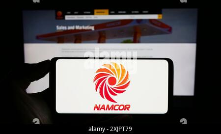 Stoccarda, Germania, 09-06-2023: Persona che detiene un cellulare con il logo della National Petroleum Corporation of Namibia (NAMCOR) sullo schermo davanti al web Foto Stock