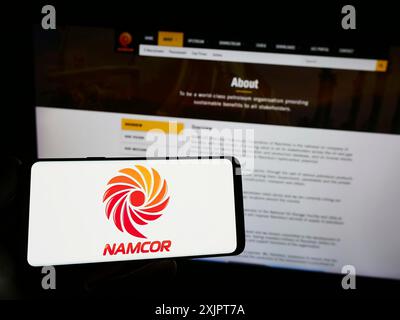 Stoccarda, Germania, 09-06-2023: Persona che possiede uno smartphone con il logo della National Petroleum Corporation of Namibia (NAMCOR) sullo schermo di fronte Foto Stock