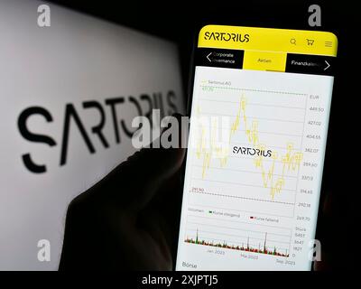 Stoccarda, Germania, 09-10-2023: Persona che possiede uno smartphone con pagina web dell'azienda farmaceutica tedesca Sartorius AG sullo schermo davanti al logo. Foto Stock