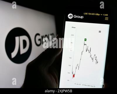 Stoccarda, Germania, 09-19-2023: Persona che detiene il cellulare con pagina web della società britannica di vendita al dettaglio JD Sports Fashion plc sullo schermo con logo. Concentrati su Foto Stock