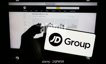 Stoccarda, Germania, 09-19-2023: Persona che possiede uno smartphone con il logo della società britannica JD Sports Fashion plc sullo schermo di fronte al sito Web. Foto Stock