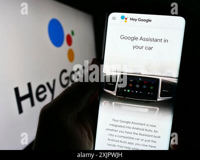 Stoccarda, Germania, 09-23-2023: Persona che tiene il cellulare con pagina web del software di assistenza virtuale Google Assistant sullo schermo con logo. Concentrati su Foto Stock