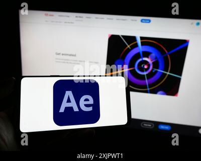 Stoccarda, Germania, 09-23-2023: Persona che tiene il cellulare con il logo del software di grafica animata Adobe After Effects sullo schermo davanti alla pagina web. Foto Stock