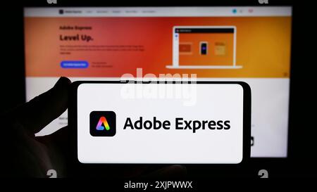 Stoccarda, Germania, 09-23-2023: Persona con smartphone con logo del software di grafica Adobe Express sullo schermo di fronte al sito Web. Concentrati su Foto Stock