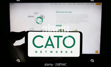 Stoccarda, Germania, 09-27-2023: Persona che detiene il cellulare con il logo della società israeliana di sicurezza di rete Cato Networks Ltd. Davanti all'azienda Foto Stock