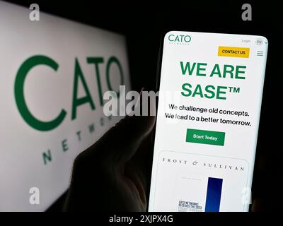 Stoccarda, Germania, 09-27-2023: Persona che detiene il cellulare con pagina web della società israeliana di sicurezza di rete Cato Networks Ltd. Davanti al logo. Concentrati Foto Stock